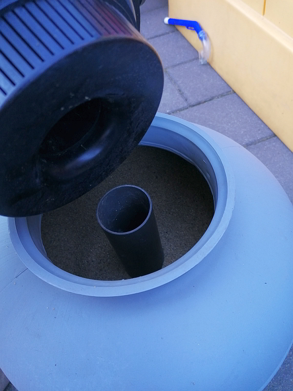 Ein kleiner Pool für den Garten. Aufbauanleitung für einen Aufstellpool - Schritt für Schritt. Hier zu sehen, wie der Steuerungsaufsatz auf dem Sandfilter festgeschraubt wird.