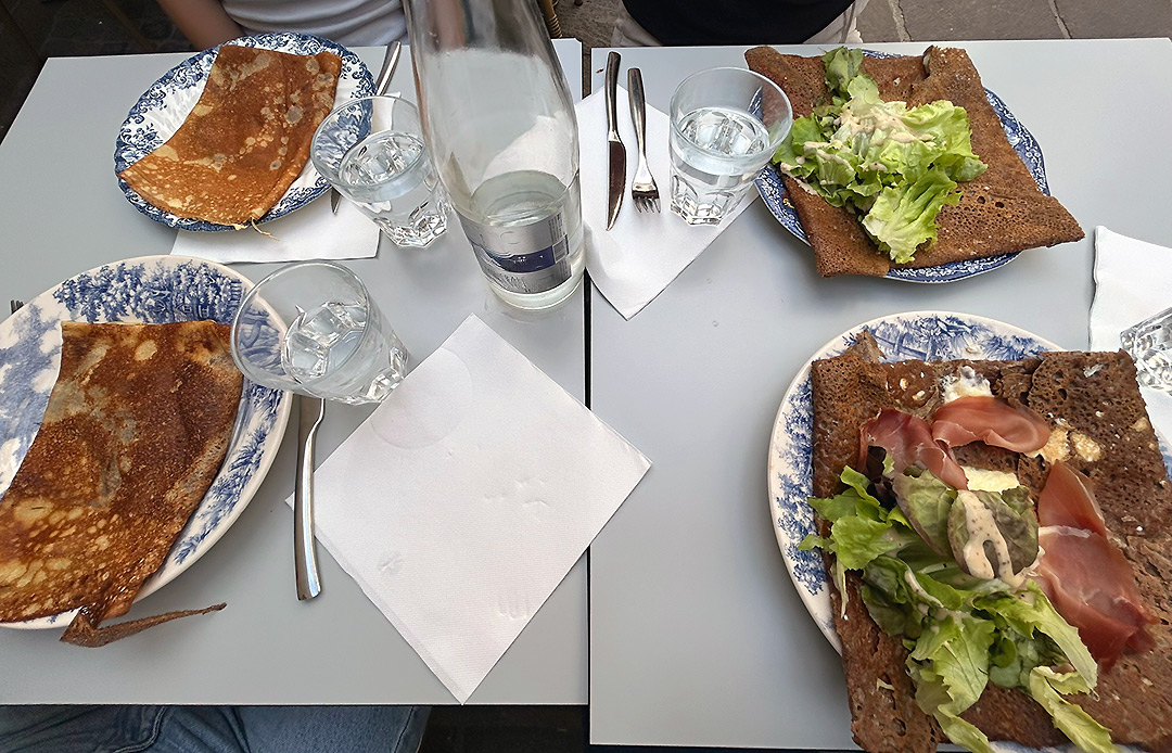 Bretagne mit Kindern - Südküste Essen mit Kindern im Süden der Bretagne: Das Bild zeigt einen Tisch mit zwei Crepes und zwei Galettes ist zu sehen. Galettes sind Buchweizenpfannkuchen mit einer herzhaften Füllung.