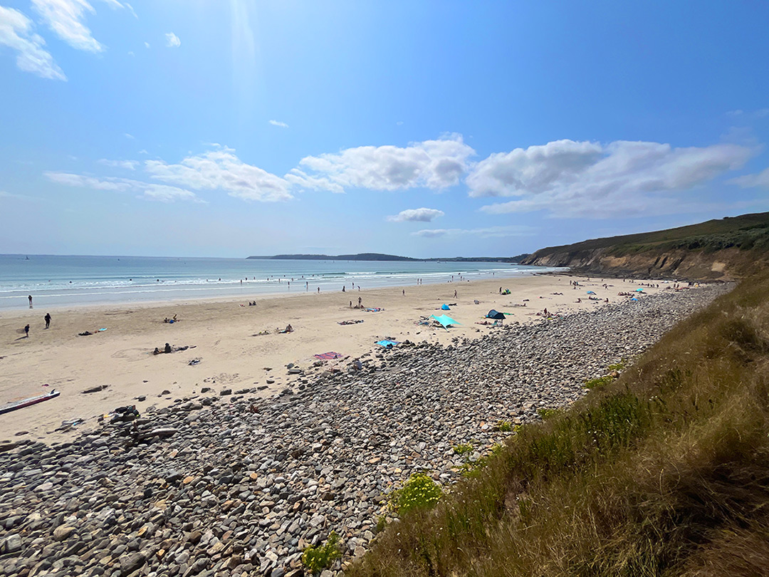 Bretagne mit Kindern - Westküste Bretagne mit Kindern - Westküste. Blick auf den Strand mit einer grünen Klippe an der Seite. Es ist ein sonniger schöner Tag.