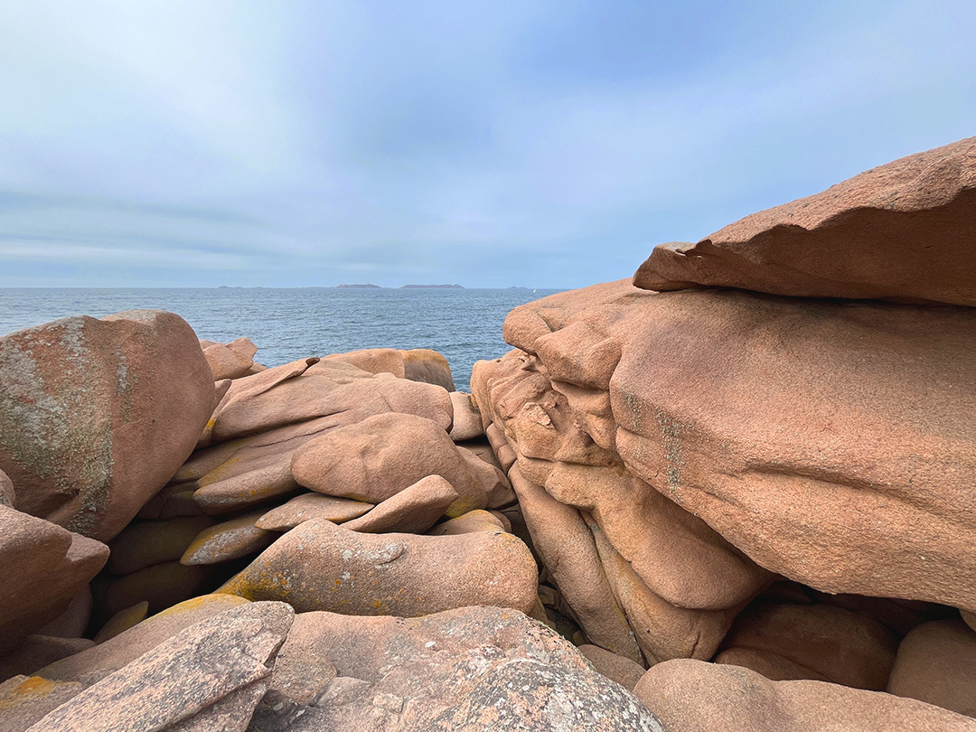 Bretagne mit Kindern - Westküste Cote de Granit Rose - Hier eine wie gestapelt wirkende Felsformation mit Blick aufs Meer.
